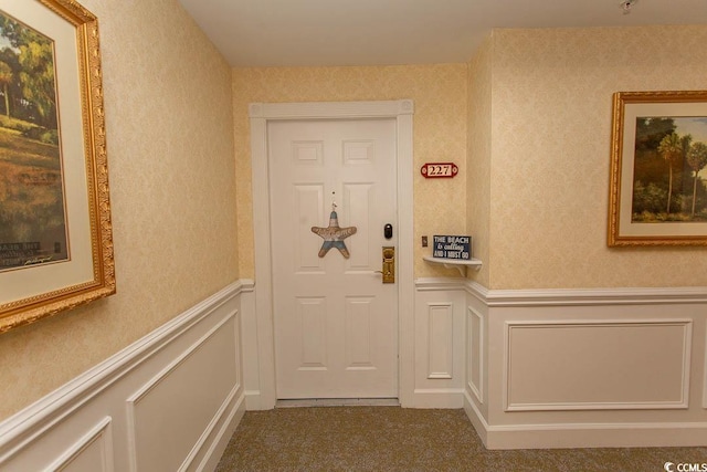 interior space with wainscoting, a decorative wall, and wallpapered walls