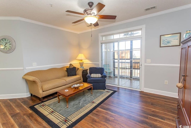 living area with crown molding, a textured ceiling, visible vents, and wood finished floors