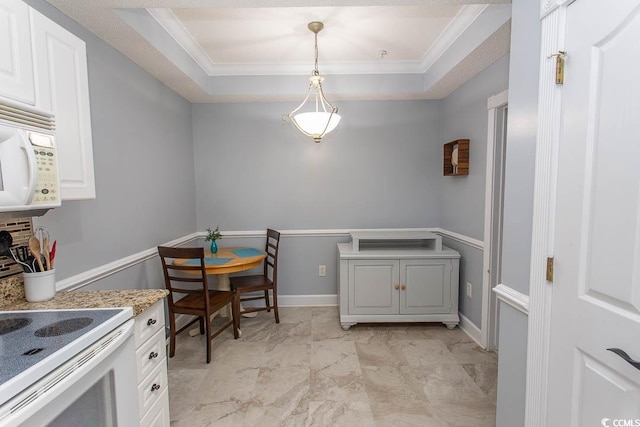 kitchen featuring white appliances, a tray ceiling, light countertops, and ornamental molding