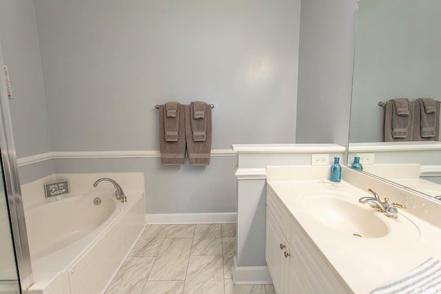 full bathroom with marble finish floor, a garden tub, vanity, and baseboards