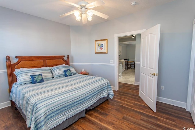 bedroom with ceiling fan, wood finished floors, and baseboards