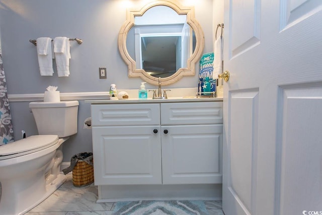 bathroom with toilet, marble finish floor, and vanity