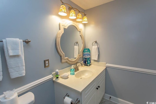 half bath with baseboards and vanity