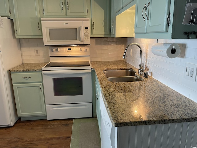 kitchen with stone counters, dark wood-type flooring, white appliances, a sink, and green cabinetry