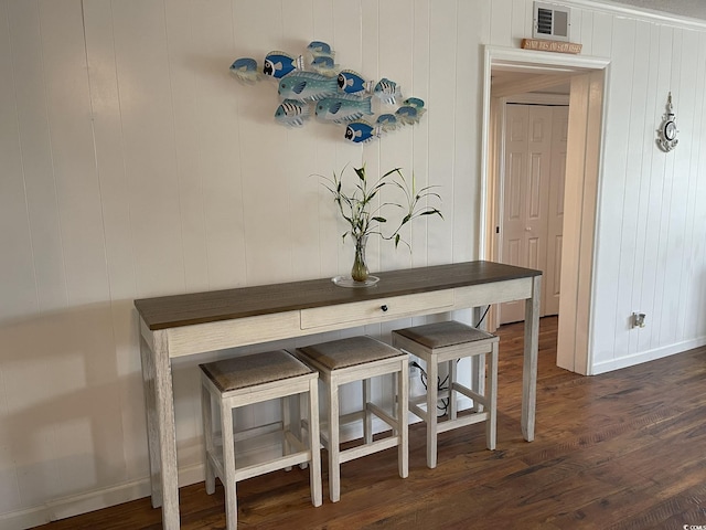 dining area with baseboards, visible vents, and dark wood finished floors