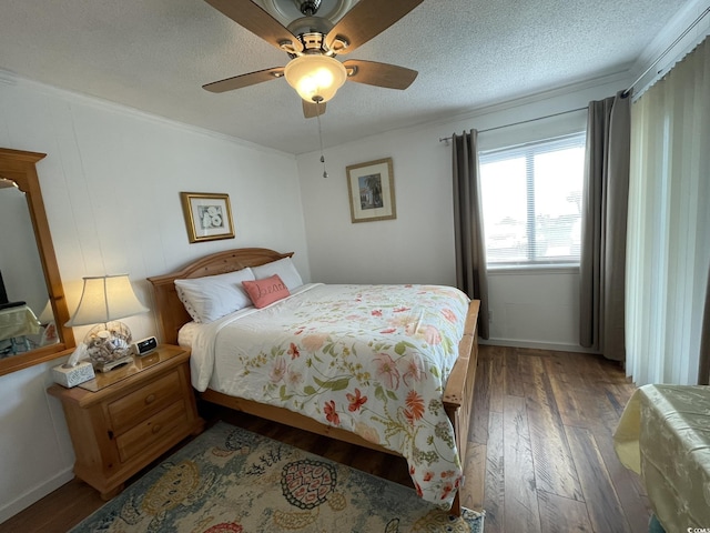 bedroom with a textured ceiling, ceiling fan, ornamental molding, and dark wood finished floors