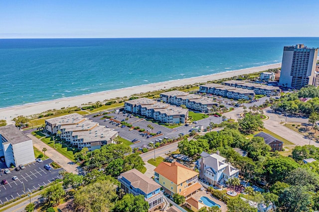 birds eye view of property with a water view and a beach view