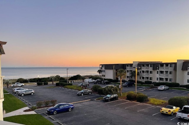 parking at dusk with uncovered parking and a water view