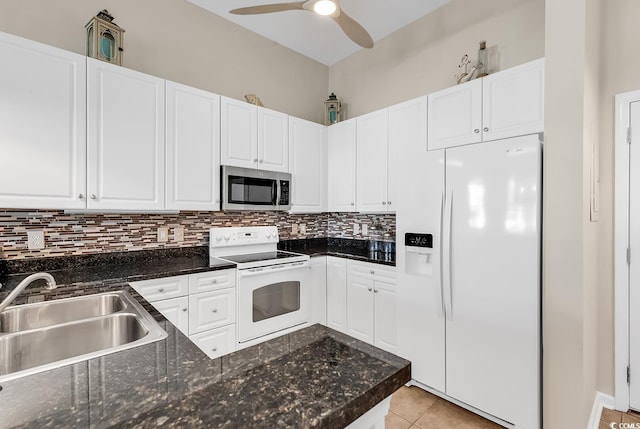 kitchen with white appliances, white cabinets, and a sink