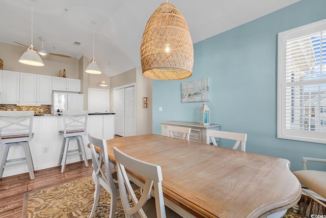 dining space with lofted ceiling and light wood-style flooring