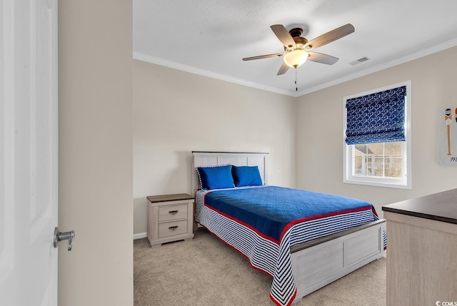 bedroom featuring ceiling fan, visible vents, crown molding, and light colored carpet