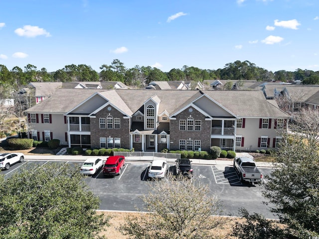 view of property with uncovered parking and a residential view