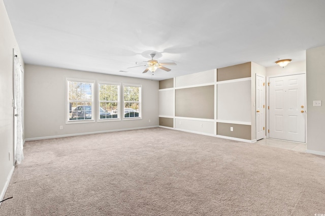 unfurnished room with a ceiling fan, light carpet, and baseboards