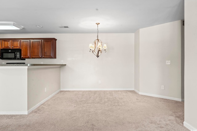 kitchen with a notable chandelier, light countertops, visible vents, light carpet, and black microwave