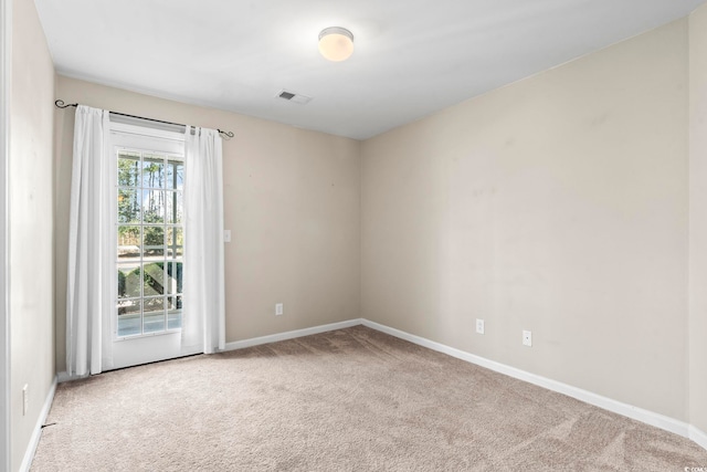 spare room with visible vents, light carpet, and baseboards