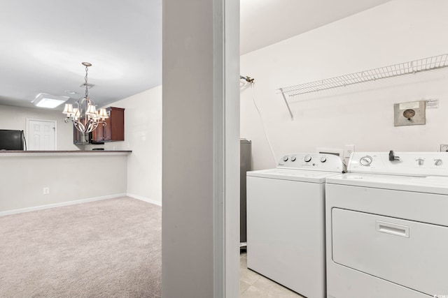 laundry room featuring laundry area, baseboards, washer and clothes dryer, light colored carpet, and an inviting chandelier