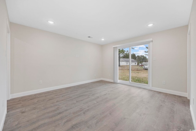 unfurnished room with visible vents, baseboards, wood finished floors, and recessed lighting