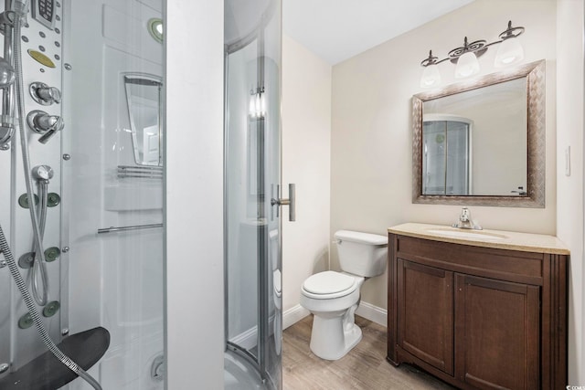 full bath featuring a stall shower, wood finished floors, toilet, and baseboards