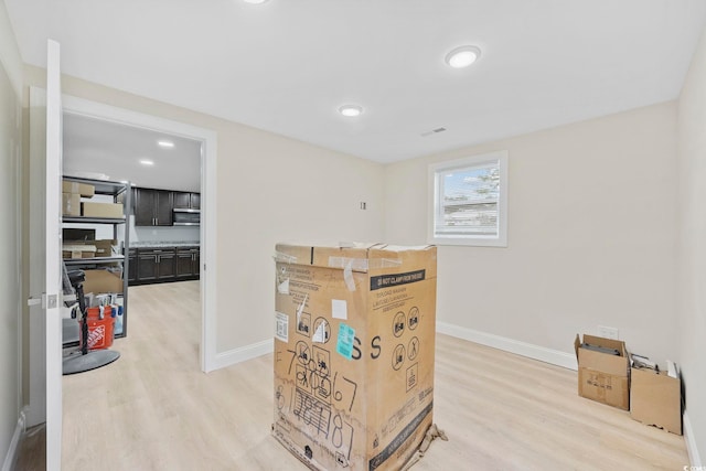 interior space with light wood finished floors, visible vents, and baseboards