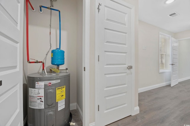 utility room with visible vents and electric water heater