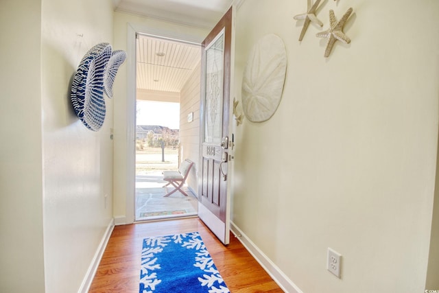 doorway featuring wood finished floors and baseboards