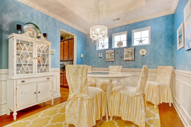 dining space with visible vents, wainscoting, light wood-style flooring, and wallpapered walls