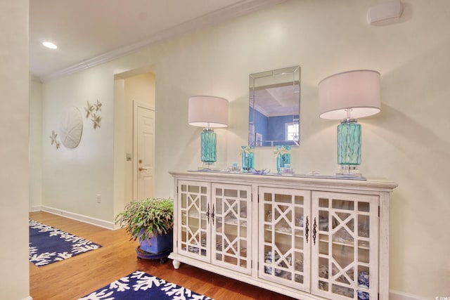 interior space with ornamental molding, recessed lighting, baseboards, and wood finished floors