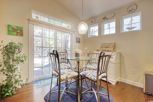 dining area with a wealth of natural light, baseboards, vaulted ceiling, and dark wood-type flooring