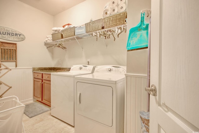 laundry area featuring washer and dryer and a wainscoted wall