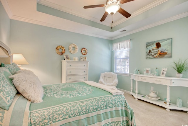 carpeted bedroom featuring a ceiling fan, a tray ceiling, visible vents, and crown molding