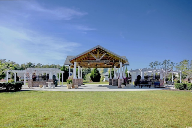 view of property's community featuring a lawn, a pergola, and a gazebo