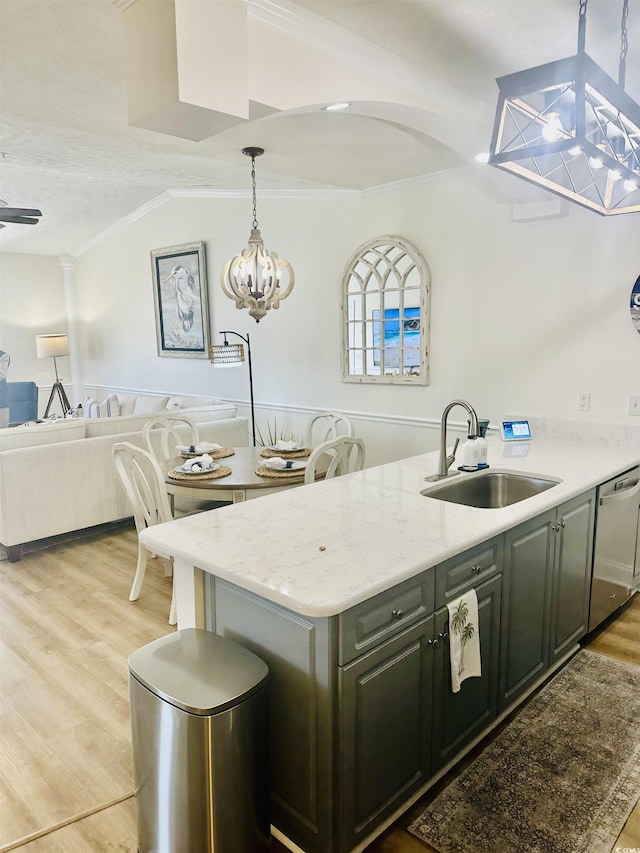 kitchen featuring decorative light fixtures, a notable chandelier, light wood-style floors, a sink, and dishwasher