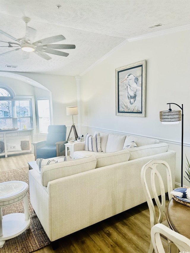 living area with lofted ceiling, dark wood-style flooring, and crown molding