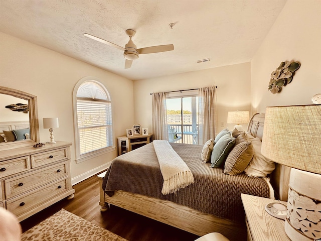 bedroom with dark wood-style flooring, a ceiling fan, a textured ceiling, access to outside, and baseboards