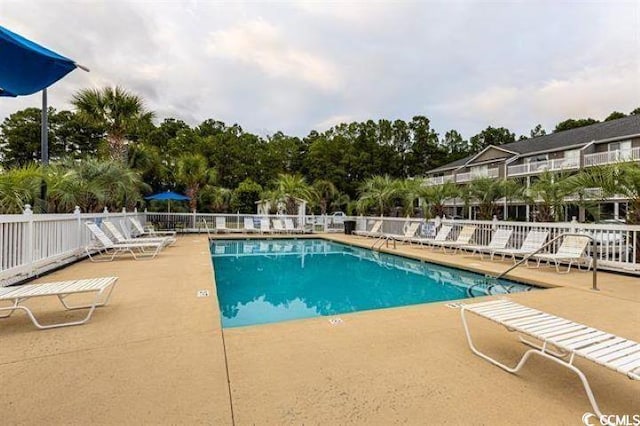 pool featuring a patio area and fence