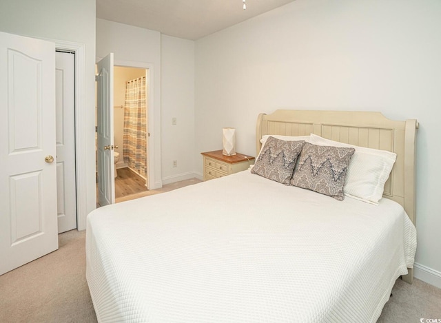 bedroom with light carpet and baseboards