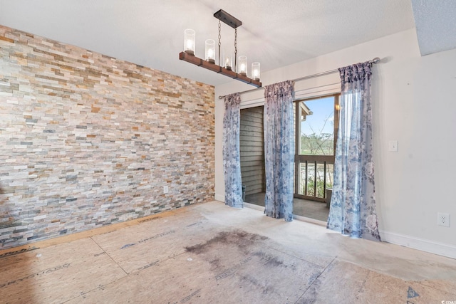 unfurnished dining area with a textured ceiling and an inviting chandelier