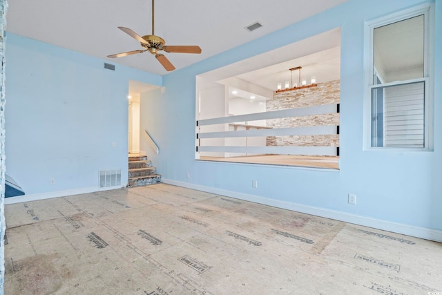 unfurnished room featuring baseboards, stairs, and visible vents