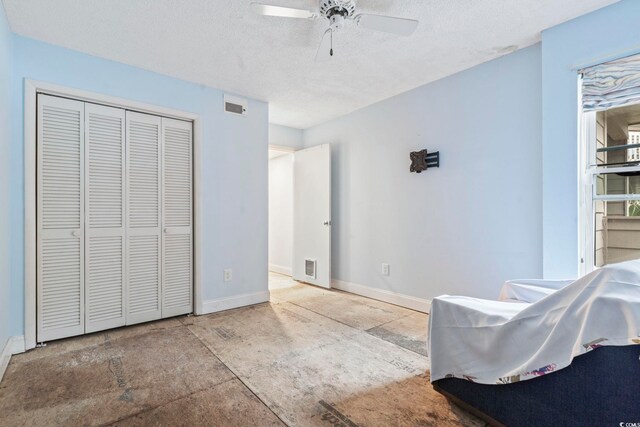 bedroom with a textured ceiling, a closet, visible vents, and baseboards