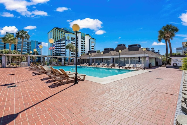 pool with a patio area and fence