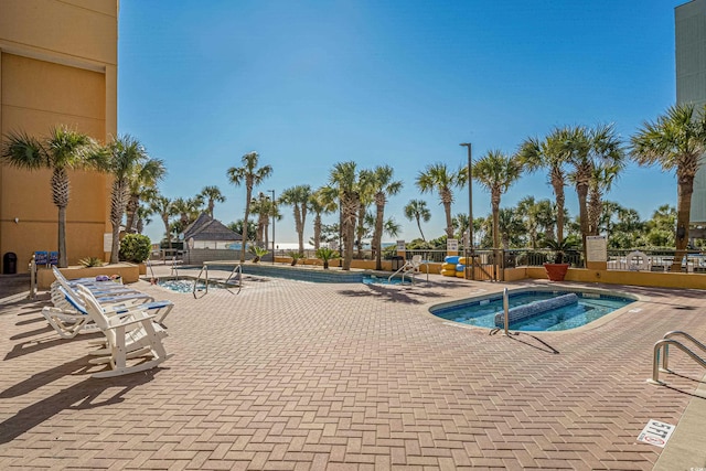 community pool featuring a community hot tub, a patio, a gazebo, and fence