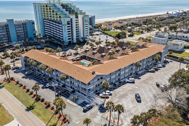 birds eye view of property with a water view and a beach view