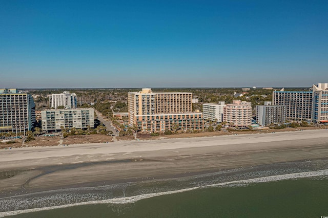 drone / aerial view with a water view, a view of city, and a beach view