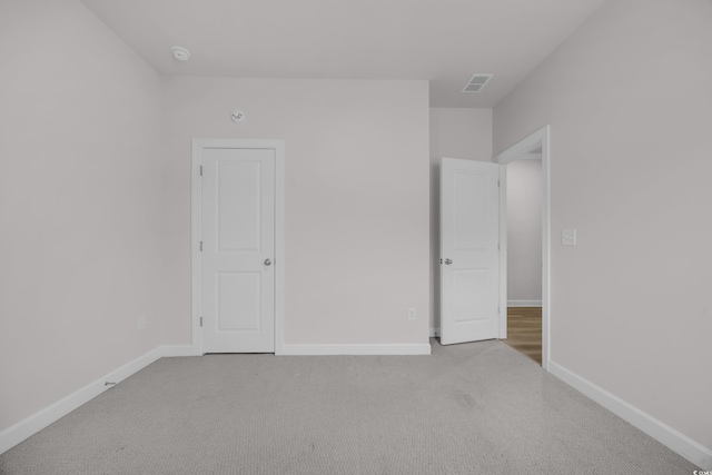 unfurnished bedroom with carpet floors, visible vents, and baseboards