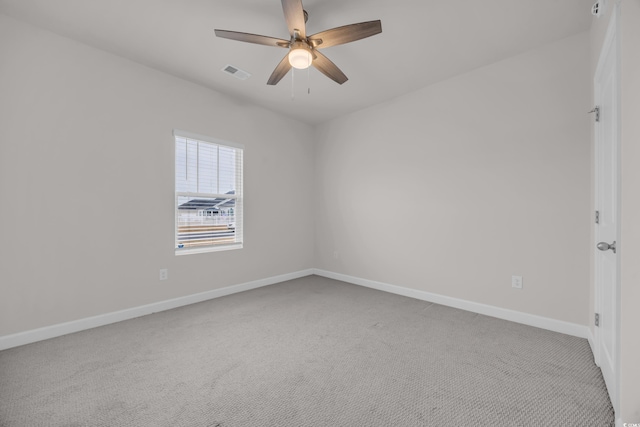 carpeted spare room with ceiling fan, visible vents, and baseboards