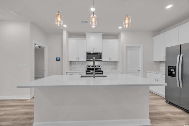 kitchen featuring visible vents, appliances with stainless steel finishes, light countertops, and a sink