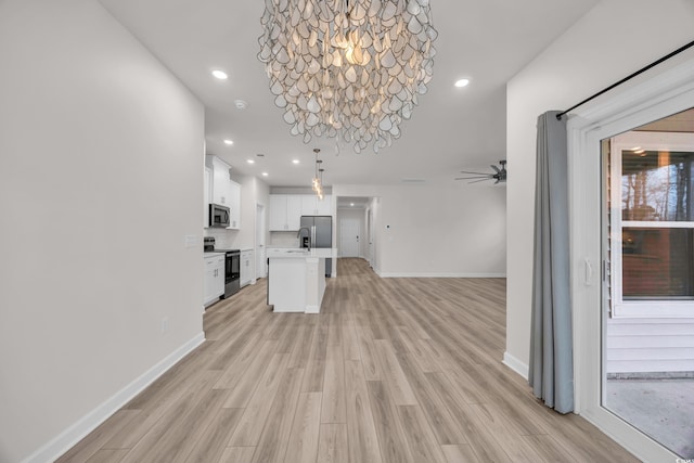 unfurnished living room featuring light wood-style floors, baseboards, a ceiling fan, and recessed lighting