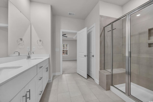 bathroom featuring a sink, visible vents, baseboards, a shower stall, and double vanity