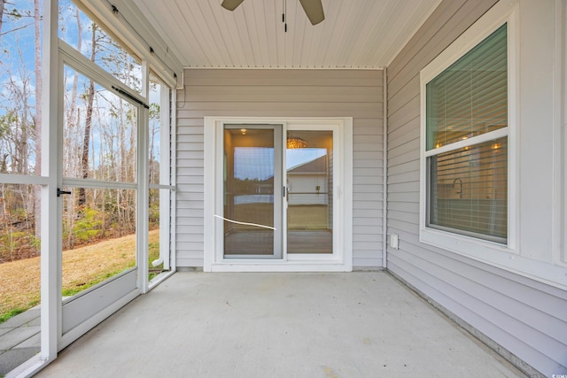 unfurnished sunroom with ceiling fan