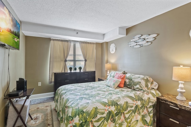 bedroom featuring baseboards and a textured ceiling